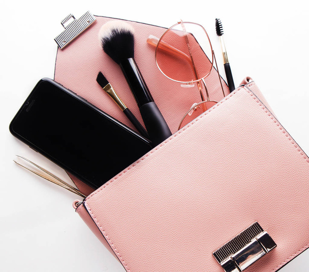 Fashion and beauty concept : Flat lay of pink leather woman bag open out with cosmetics and accessories - Φωτογραφία, εικόνα