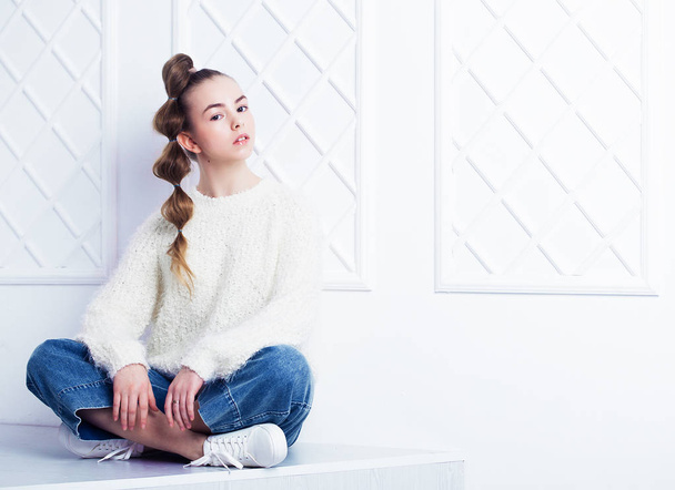 Beautiful little fashion model on white background. Portrait of cute smiling girl posing in studio - Фото, изображение