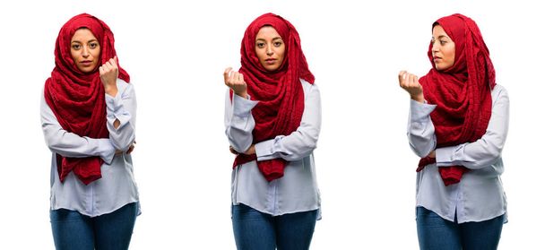 arabische Frau trägt Hijab mit verschränkten Armen selbstbewusst und ernst isoliert vor weißem Hintergrund - Foto, Bild