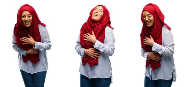 アラブの女性が白い背景で隔離された笑って自然な笑顔で自信と幸せのヒジャーブを着て - 写真・画像