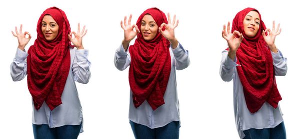 Araberin im Hijab macht ok Zeichen Geste mit beiden Händen zum Ausdruck Meditation und Entspannung isoliert über weißem Hintergrund - Foto, Bild