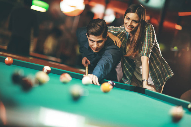 Young couple playing pool in the bar - Photo, Image