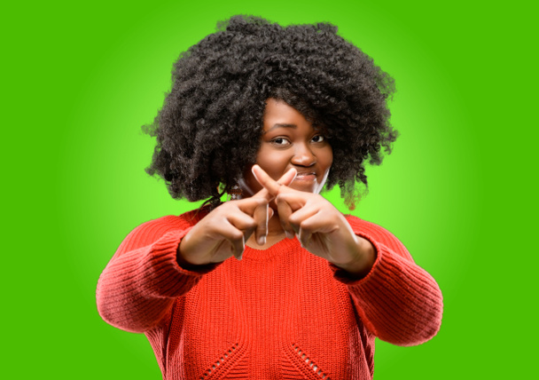 Красивая африканская женщина раздражена плохим отношением, делая знак "стоп" рукой, говоря нет, выражая безопасность, защиту или ограничение, может быть, толкая
 - Фото, изображение