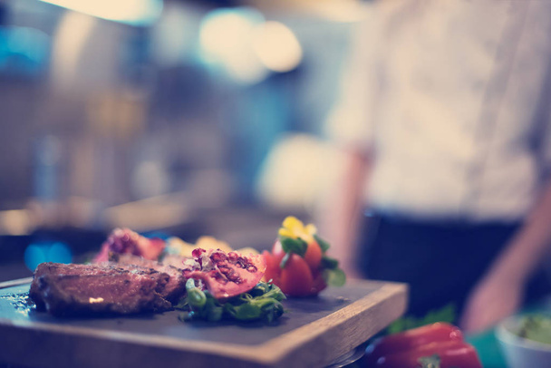Juicy slices of grilled steak on wooden board - Fotó, kép