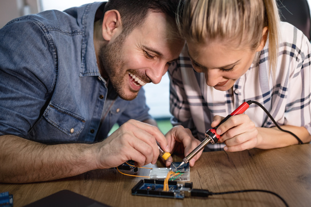 Two young business partners technician focused on repairing of electronic equipment - Foto, Imagem