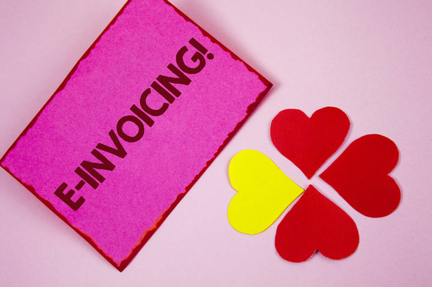 Sana kirjoittaa tekstiä E-Laskutus Motivational Call. Yrityksen liiketoimintakonsepti kannustaa käyttämään digitaalista laskutusta, joka on kirjoitettu Sticky Note paperille tavalliselle vaaleanpunaiselle taustalle Paperi Hearts vieressä
. - Valokuva, kuva