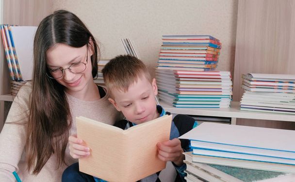 Mom and son read a book together and and laughing. Mom in glasses. - Foto, Imagen
