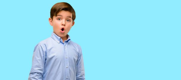 Красавчик ребенок с зелеными глазами счастливый и удивленный приветствуя выражение вау жест на голубом фоне
 - Фото, изображение