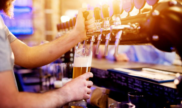 χέρια του σερβιτόρου έκχυση παγωμένη μπύρα σε ποτήρι  - Φωτογραφία, εικόνα