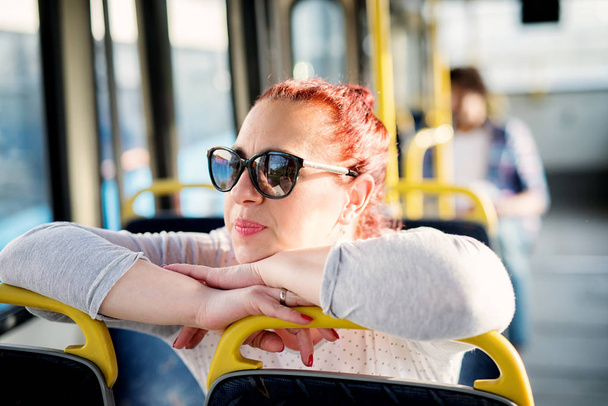 young pretty woman sitting on a bus seat - Zdjęcie, obraz