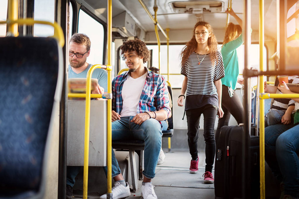 groep jonge passagiers in de bus, stadsvervoer  - Foto, afbeelding