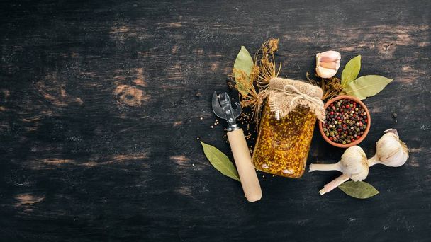 Pickled mustard in a jar. Stocks of food. Top view. On a wooden background. Copy space. - Фото, зображення