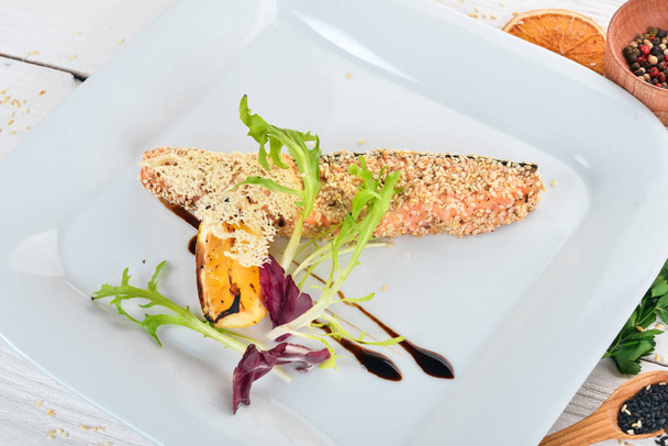 Fish salmon fillet baked with sesame seeds. Top view. On a wooden background. Copy space. - Foto, Bild