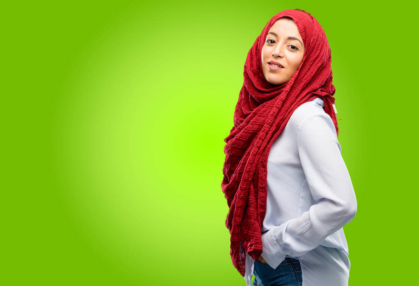 Jonge Arabische vrouw het dragen van hijab zelfverzekerd en blij met een grote natuurlijke glimlach lachen - Foto, afbeelding