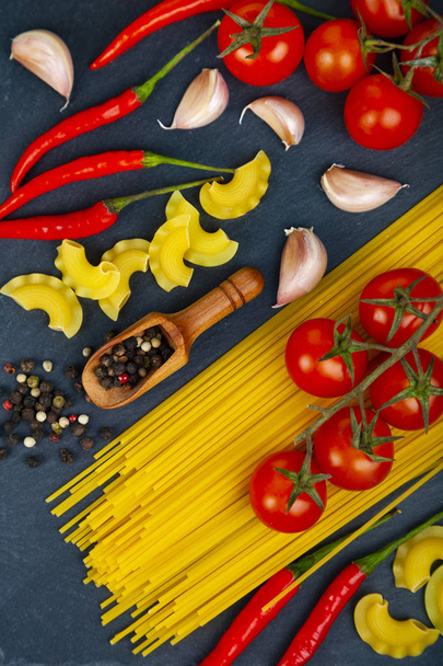 Different pasta on a dark wooden background - Фото, изображение