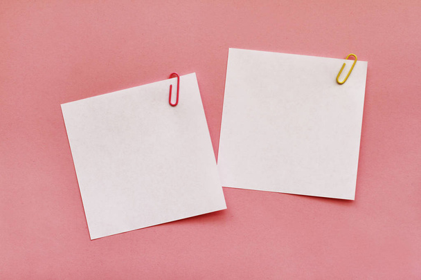 Two white note papers with clips on pink background - Foto, Imagen