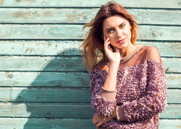 fashion girl posing near a turquoise wooden wall - Foto, Imagen