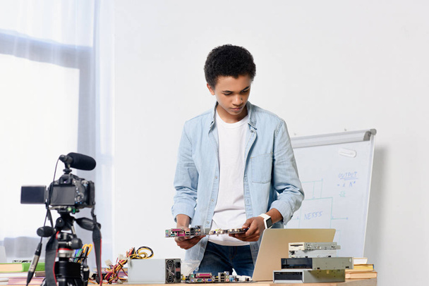 afrikanisch-amerikanischer Teenager bereitet Dreharbeiten für Tech-Videoblog zu Hause vor - Foto, Bild