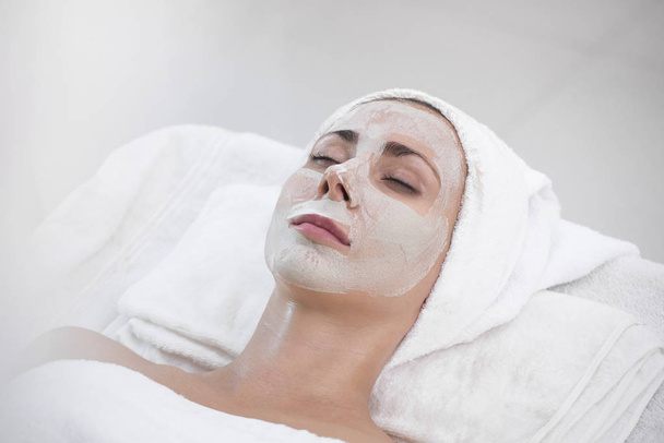 Massaggiatore facendo maschera alla panna sul viso di bella giovane donna rilassarsi
 - Foto, immagini
