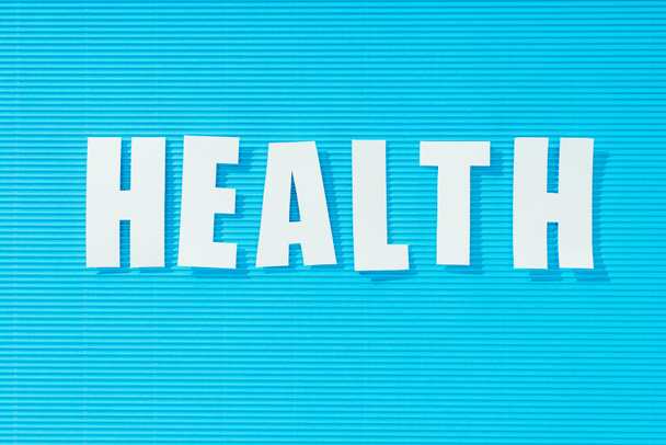 white word health on bright blue striped background, health concept - Фото, изображение
