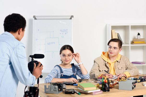 multiethnic teenagers shooting video blog about engineering at home - Photo, Image
