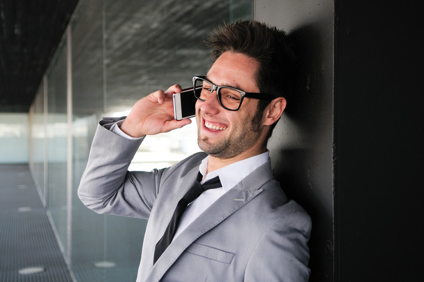 Portrait of handsome man in urban background talking on phone - Фото, изображение