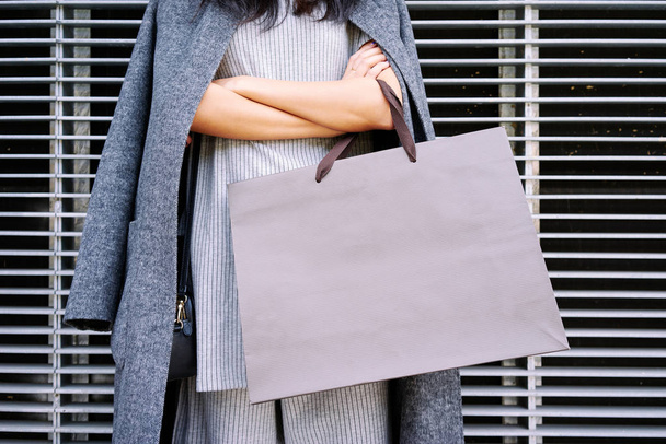 Close up female hands holding a blank paper bag with empty space for your text - 写真・画像