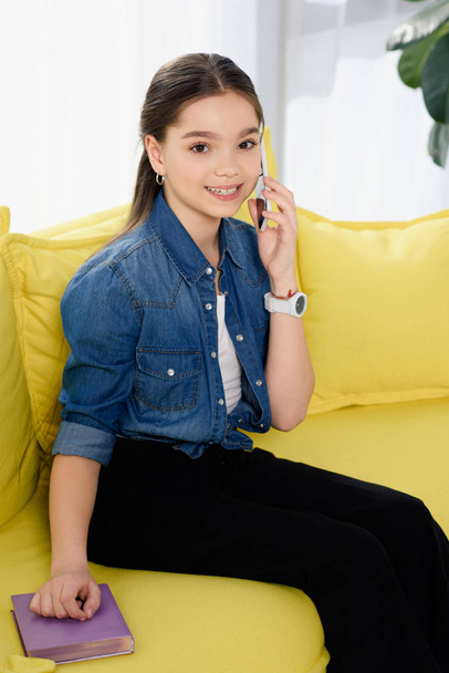 adorable preteen child talking by smartphone at home - 写真・画像