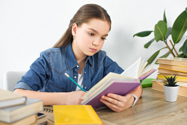 adorable preteen child doing homework at home - Photo, Image