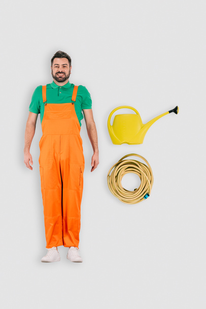 top view of male gardener with watering can and hose isolated on white background - Photo, Image