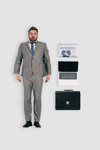 vue du dessus de l'homme d'affaires avec journal, ordinateur portable et serviette isolé sur fond blanc
 - Photo, image