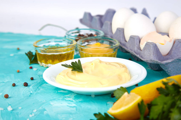 Σπιτική σάλτσα μαγιονέζας και υλικά αυγά, λάδι, λεμόνι, mustar σε μπλε φόντο. Κορυφή vie - Φωτογραφία, εικόνα
