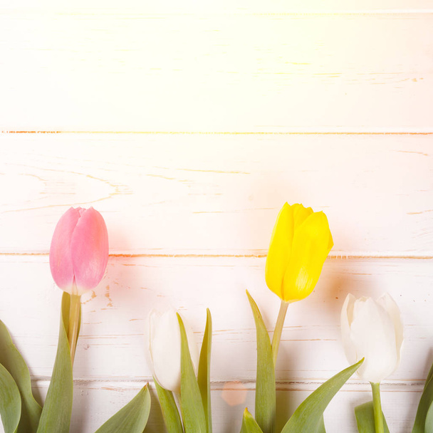 bouquet of purple, yellow and white tulips on a wooden background - Photo, image