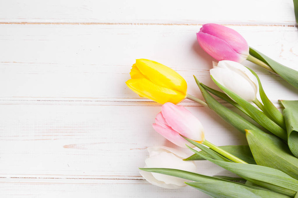 bouquet of purple, yellow and white tulips on a wooden background - Foto, Bild