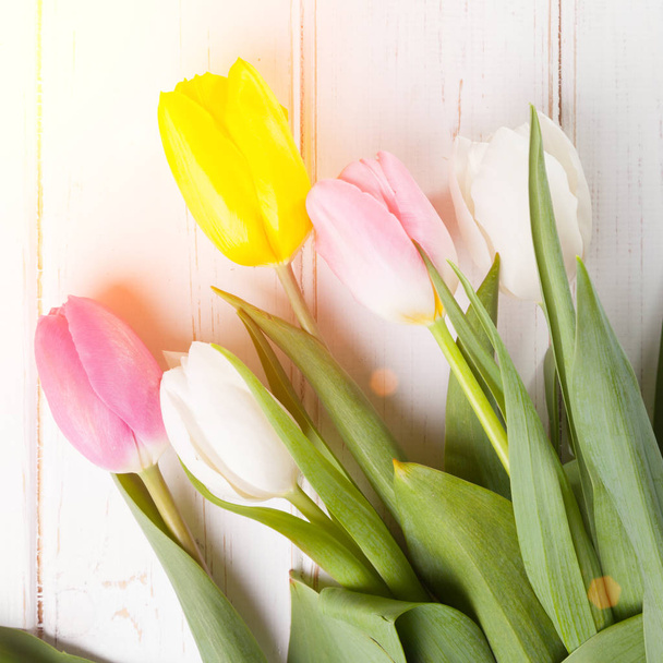 bouquet of purple, yellow and white tulips on a wooden background - Фото, зображення
