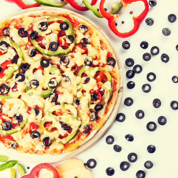 Tasty pizza with vegetables, chicken and olives on white - Foto, afbeelding