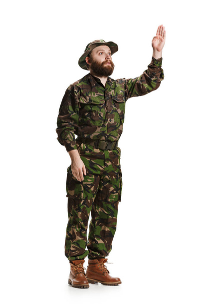 Young army soldier wearing camouflage uniform isolated on white - 写真・画像