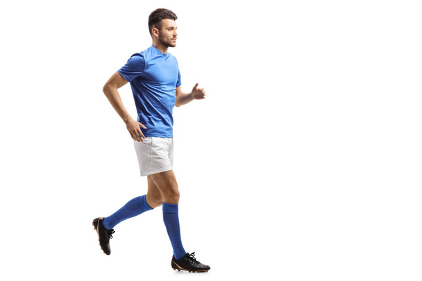 Perfil de comprimento total tiro de um jogador de futebol correndo isolado em fundo branco
 - Foto, Imagem