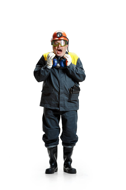 The studio shot of senior bearded male miner standing at the camera on a white background. - Foto, afbeelding