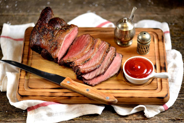 Roast beef copper on a wooden cutting board - Photo, Image
