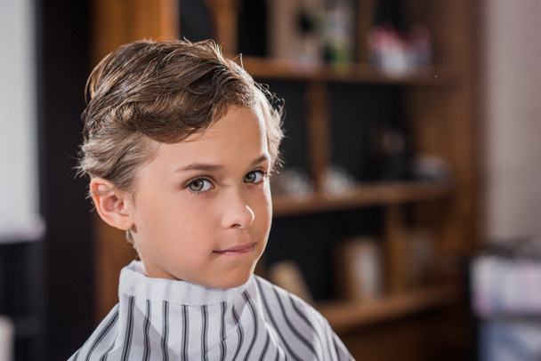 primer plano de adorable niño cubierto con tela a rayas en la barbería
 - Foto, Imagen