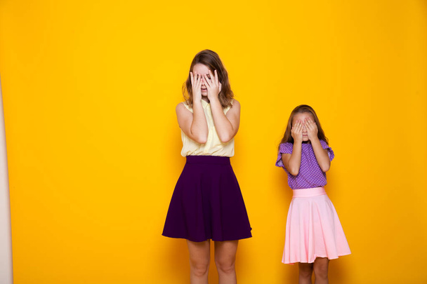 dos chicas cierran los ojos con las manos
 - Foto, Imagen