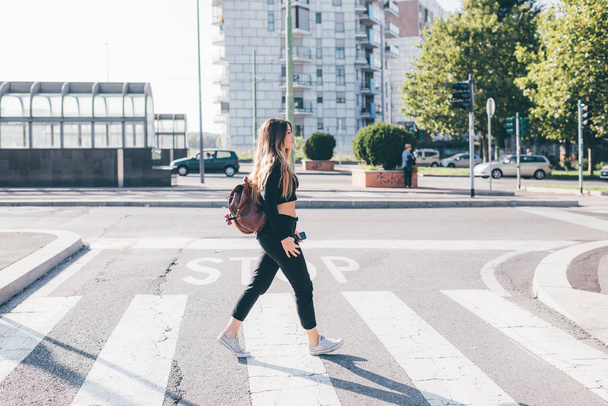 junge Frau läuft auf Zebrastreifen  - Foto, Bild