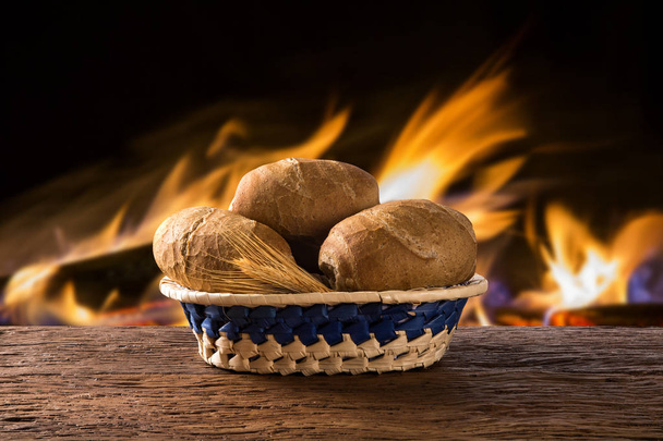 Basket of "Integral French bread", traditional Brazilian bread with fire background - Fotó, kép