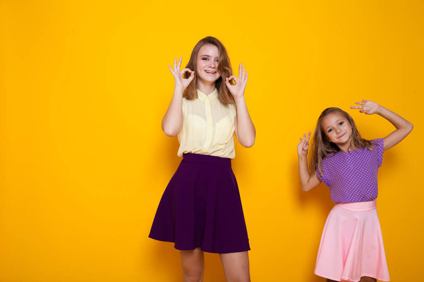 дві дівчини показують пальці і сміються
 - Фото, зображення