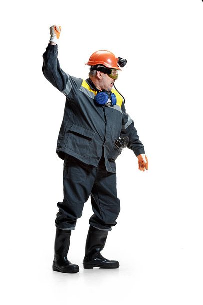 The studio shot of senior bearded male miner standing at the camera on a white background. - Foto, Imagen