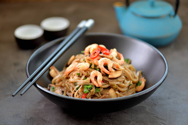 Buckwheat noodles soba with shrimp, vegetables and mushrooms. - Photo, Image