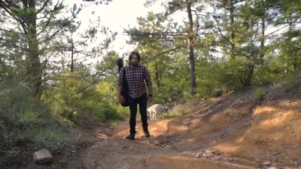 man with guitar walking with two siberian husky dog in forest - Video