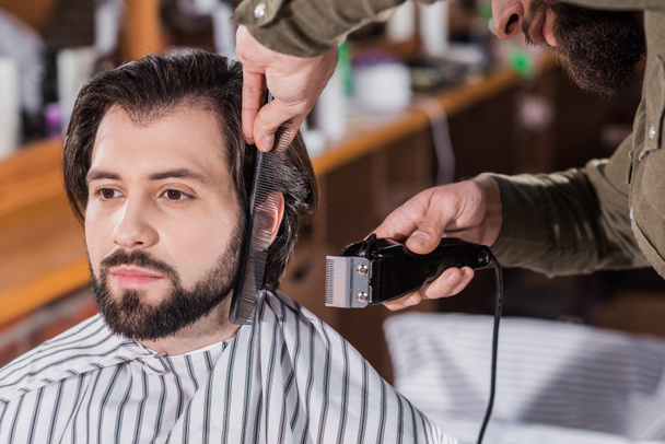 close-up shot of barber shaving man with Hair Clipper - Photo, Image