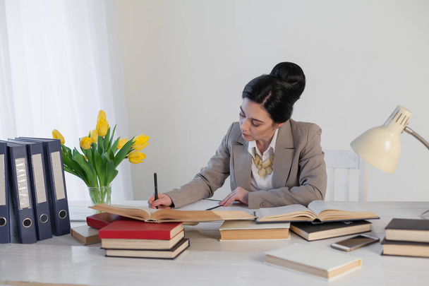 a woman in a business suit writes entries for table - Foto, Imagem